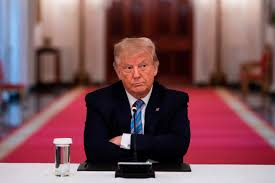 President Donald Trump sitting at a table. 