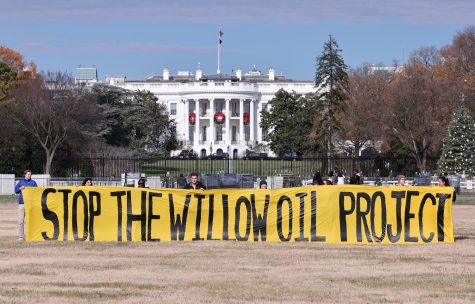 Protesters showing their frustrations by holding a sign that says STOP THE WILLOW PROJECT in front of the White House. Photographed by Paul Morigi of Getty Images.