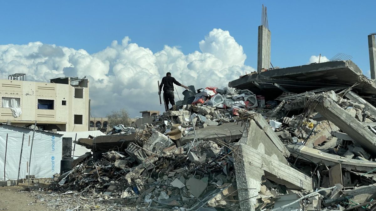 Man in Gaza standing above the remains of houses after Israeli Attack